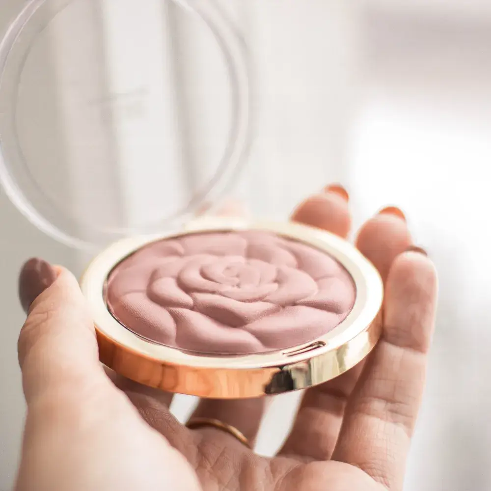 hand holding a compact powder foundation for oily skin