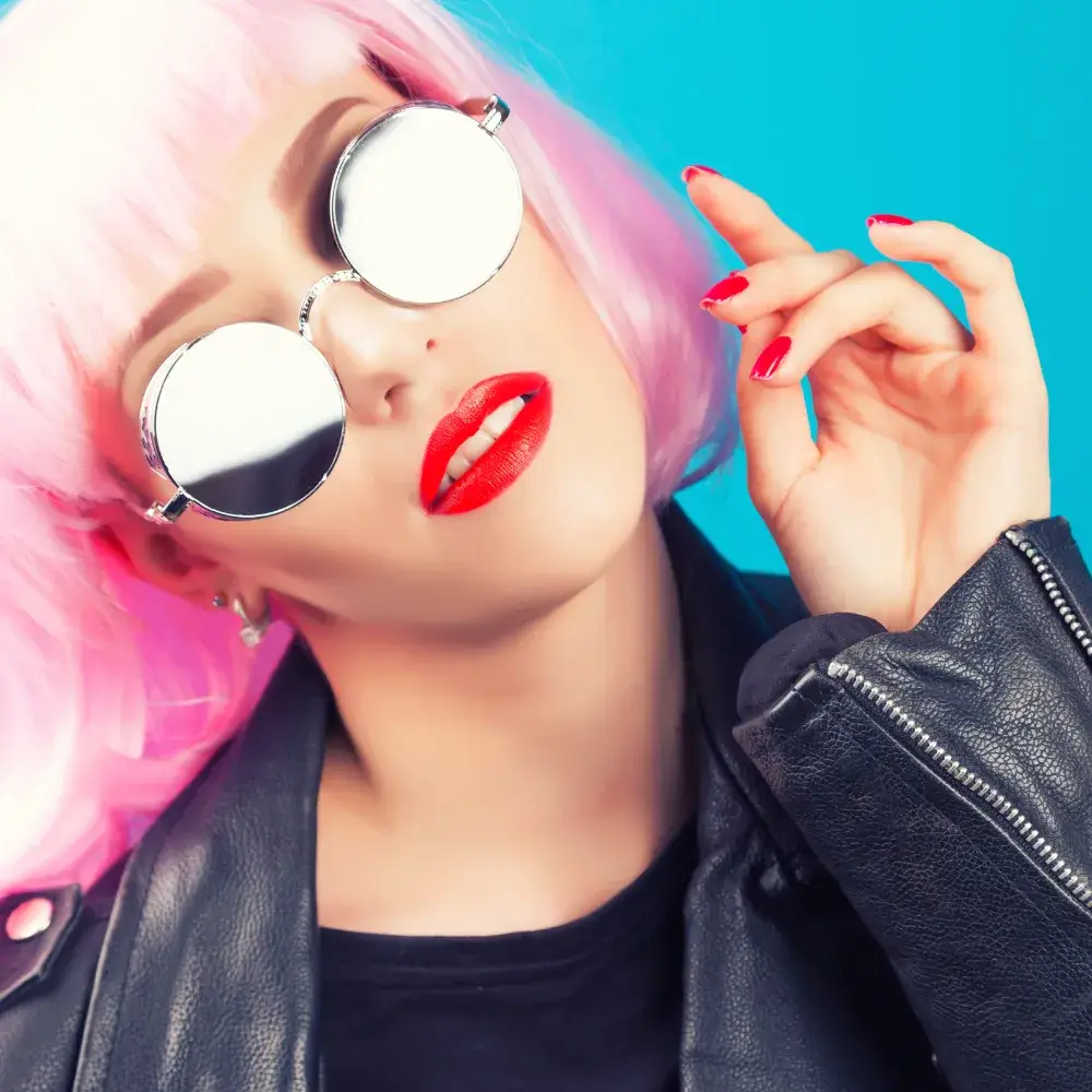 woman with pink wig wearing red lipstick and silver eyeglasses