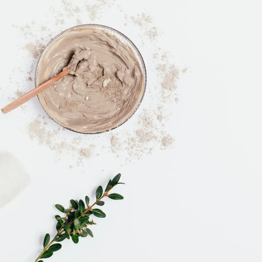 clay mask in a glass bown against a white background