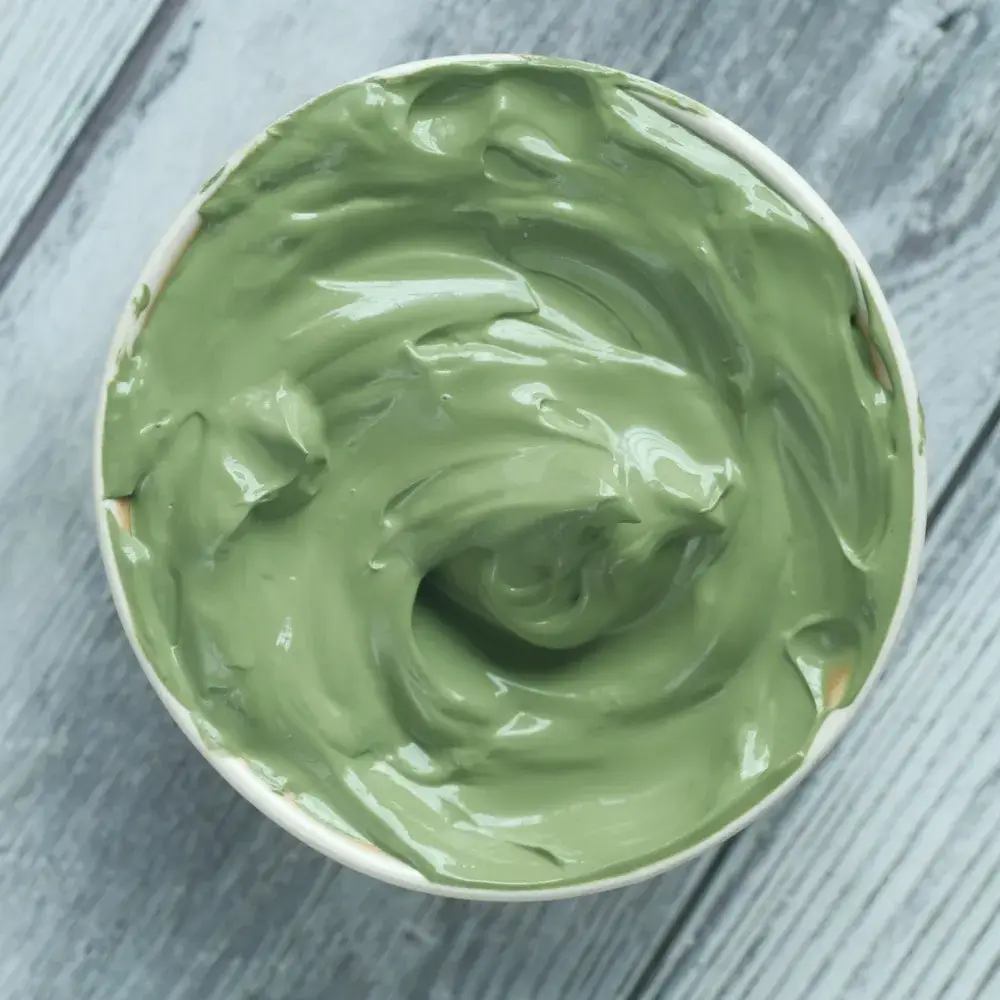green clay mask on a wooden background