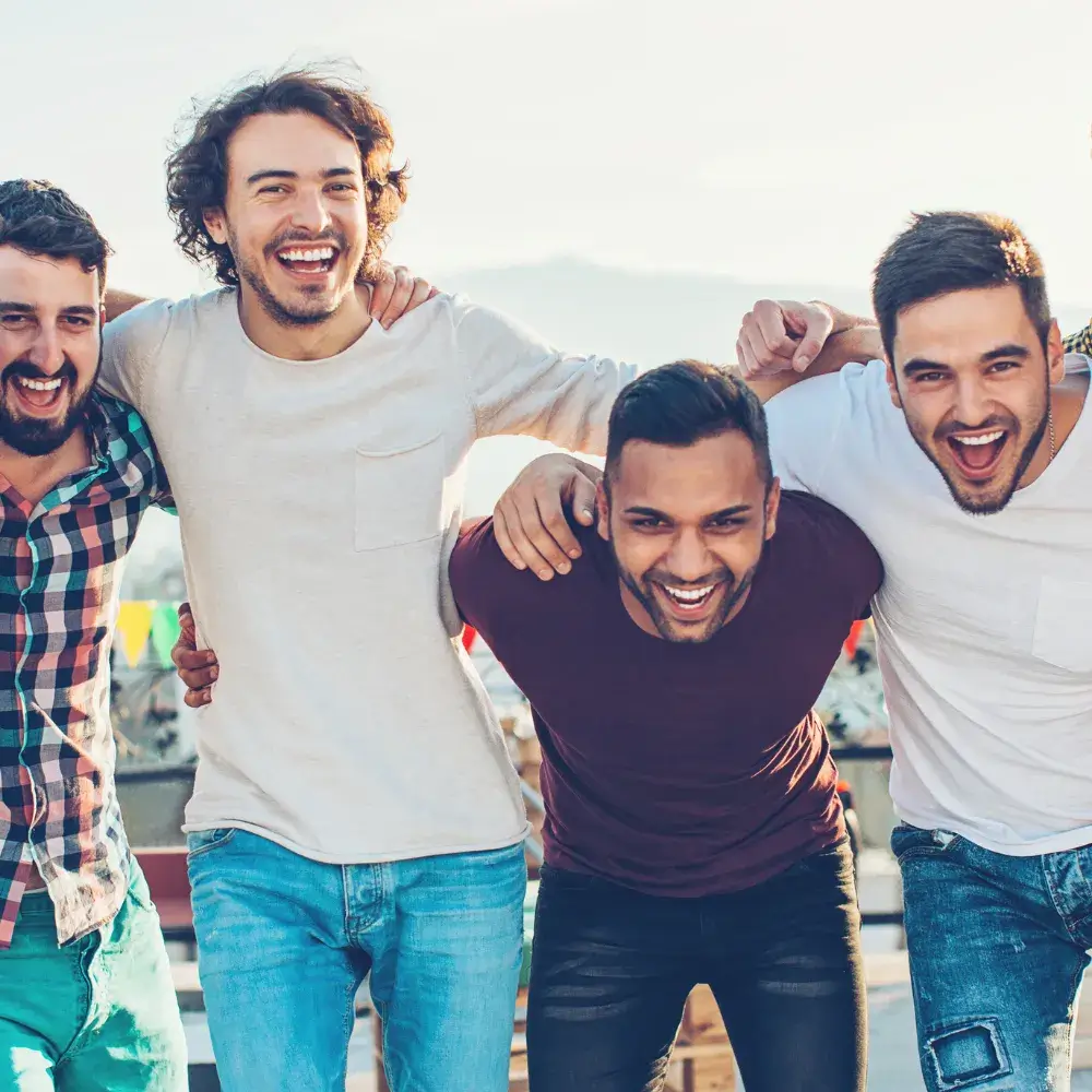 group photo of young men smiling outdoors