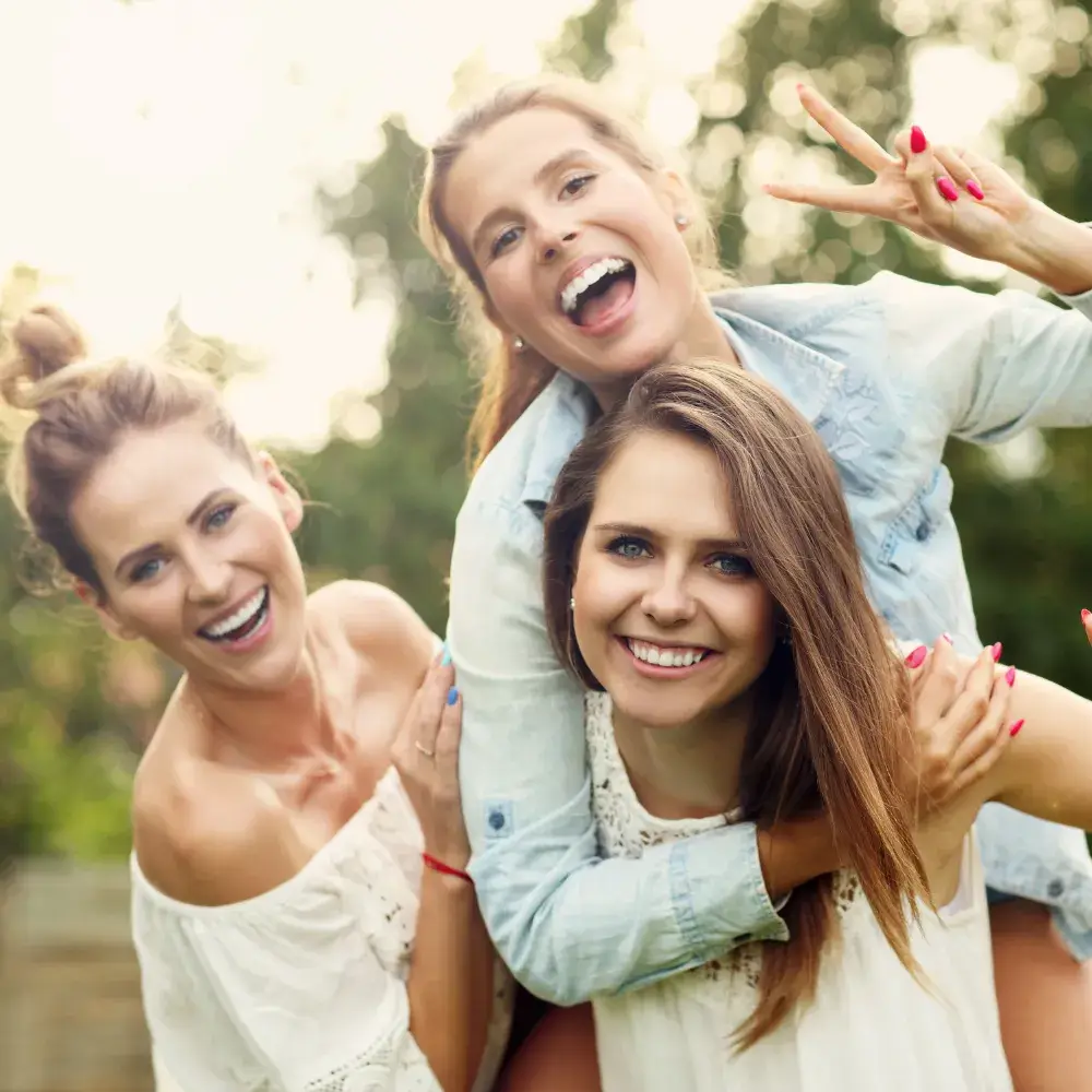 three happy women smiling and posing outdoors
