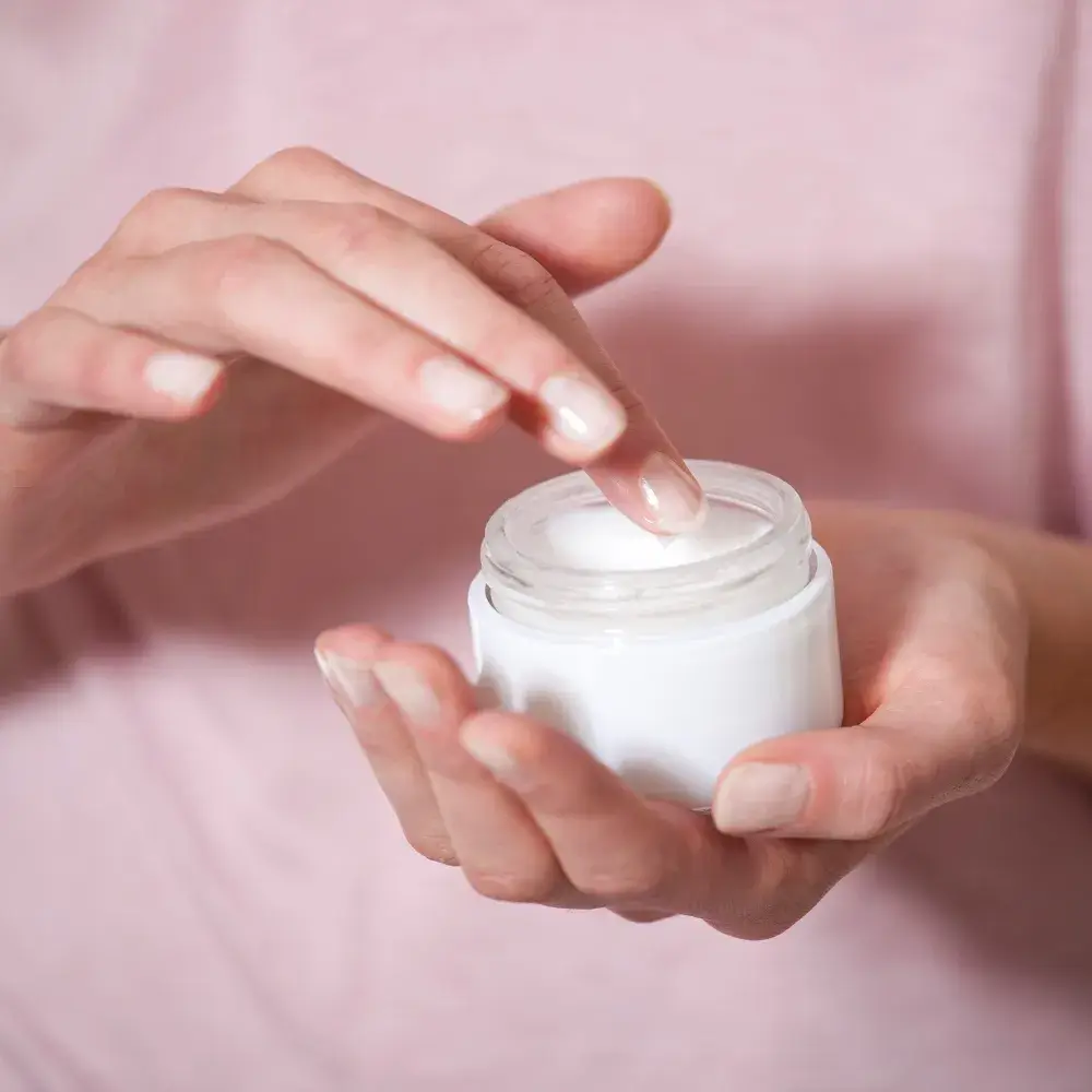 close up of a woman's hands holding a moizturizing cream