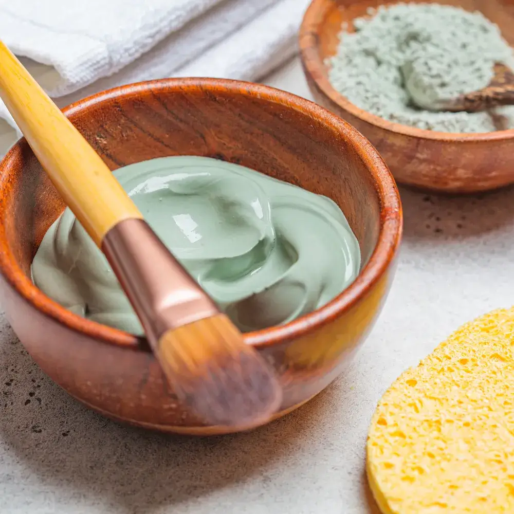 Wooden bowls containing a homemade, natural green clay mask.