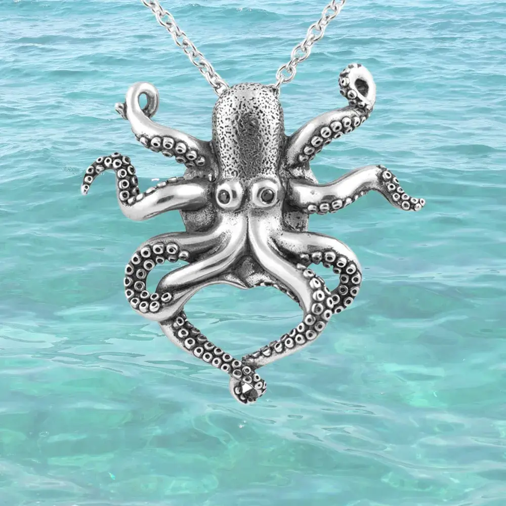 silver octo necklace against a turquoise-colored sea