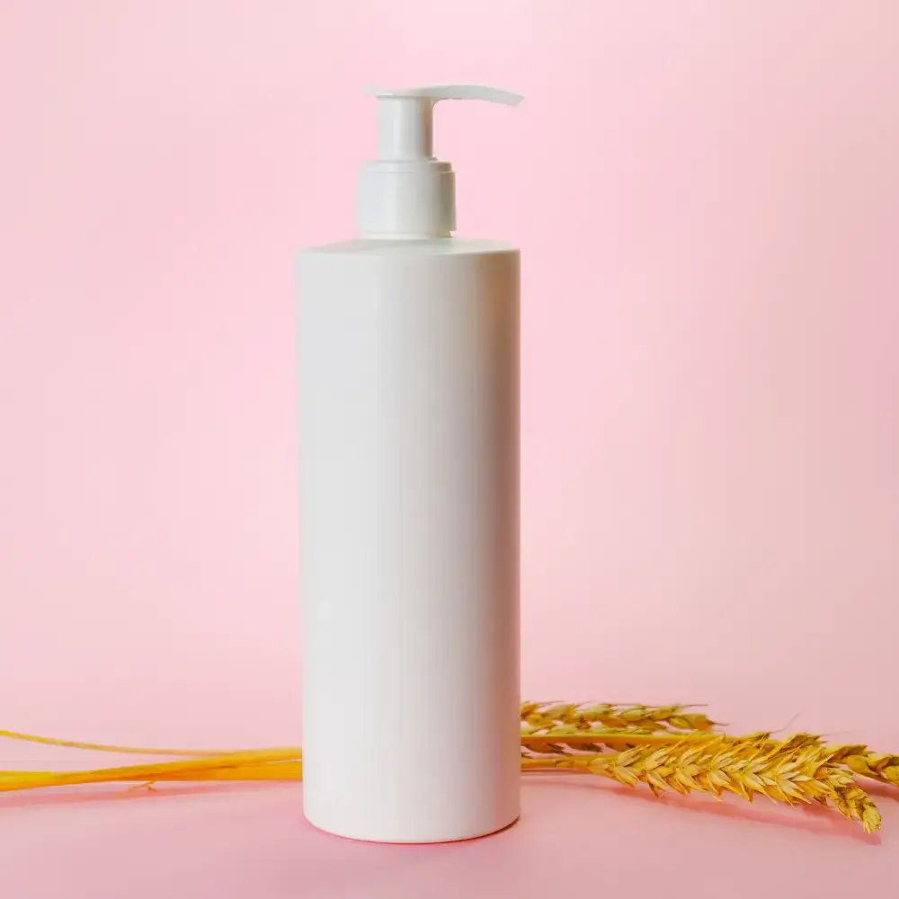 white shampoo bottle against a pink background