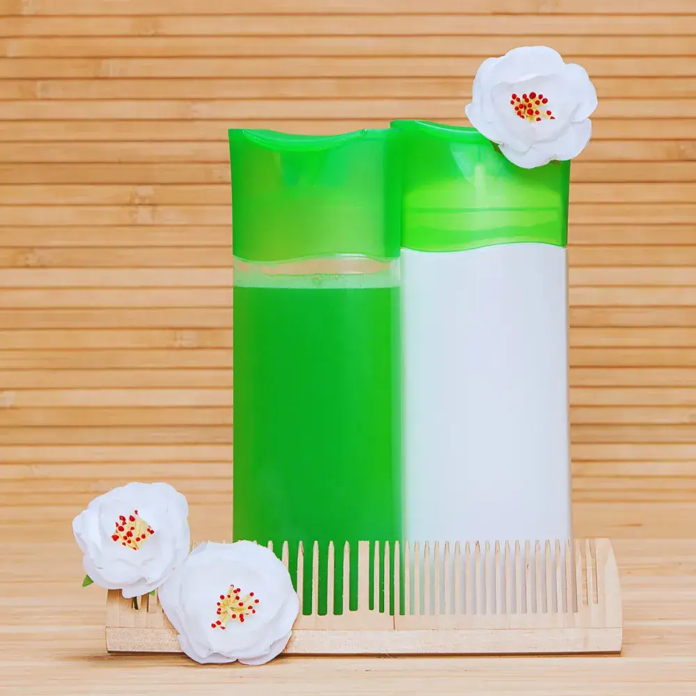 green and white shampoo bottles with comb and white flowers