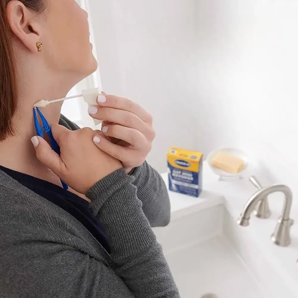 woman using skin tag remover on her neck