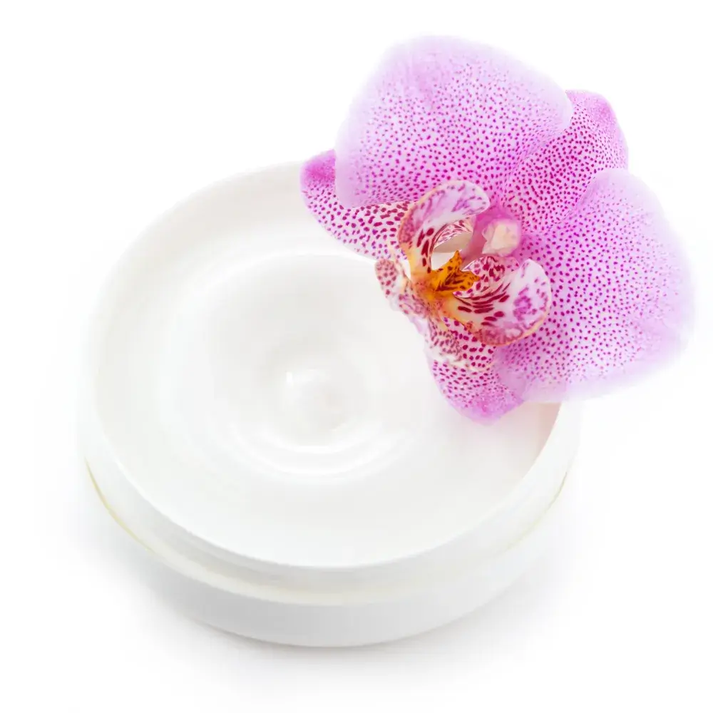 hand cream in a container with pink orchid