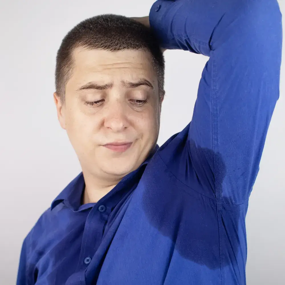 man in blue shirt with sweaty underarms
