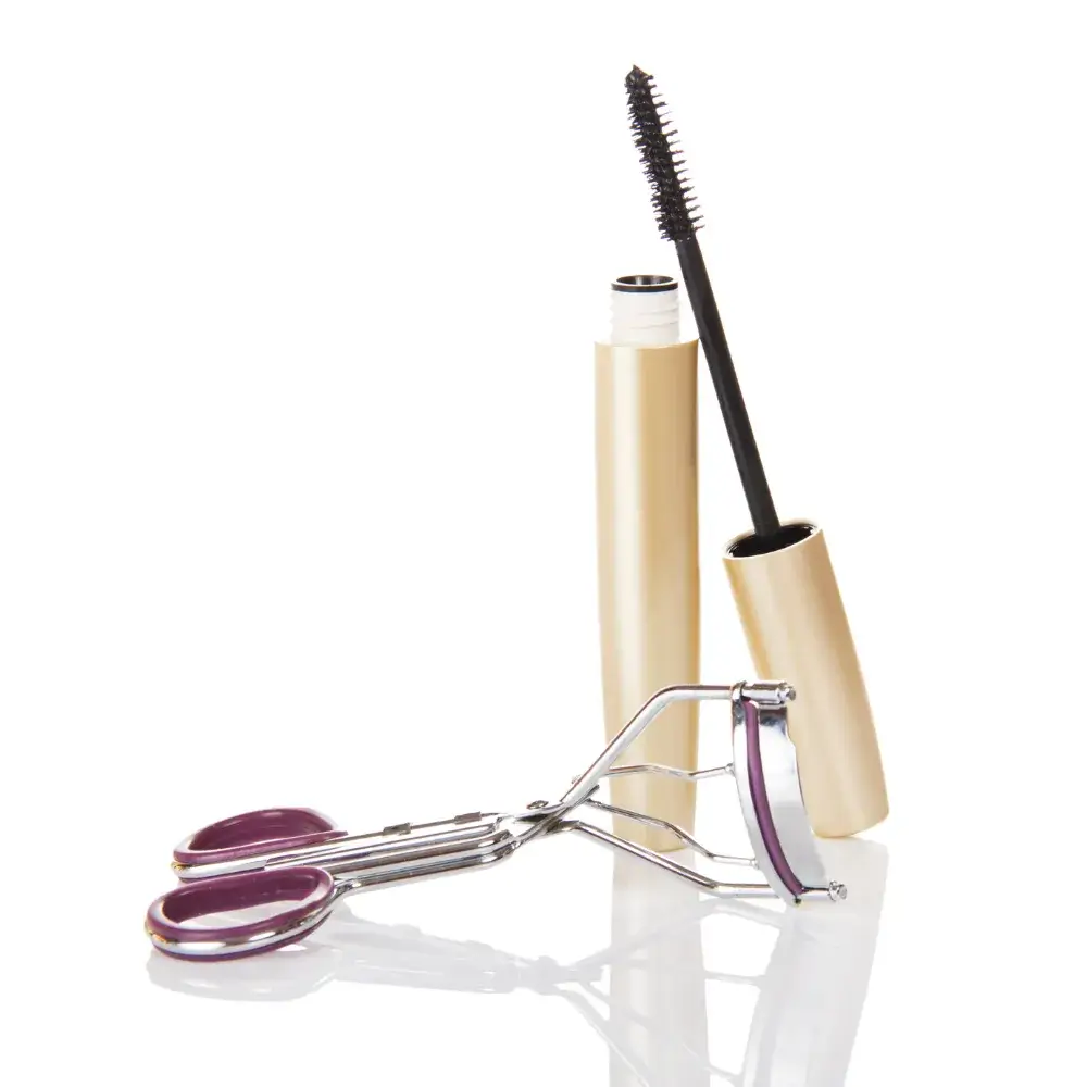 A black mascara and a lash curler are on a white background