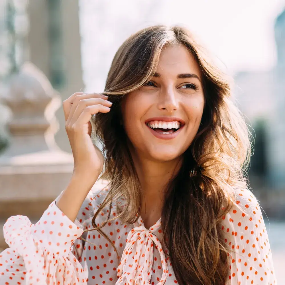 close up portrait of a woman smiling in a red polka dot top