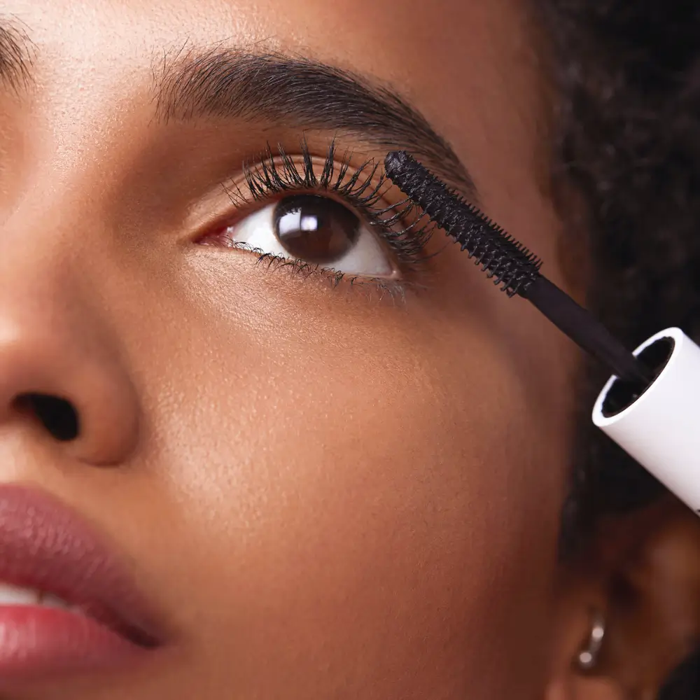 close up of a black mascara being applied on a woman's eye