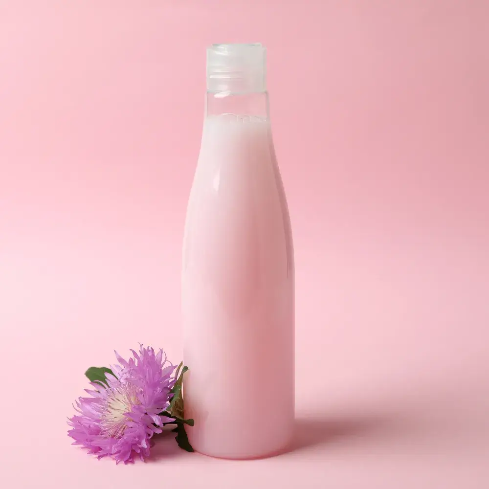pink shampoo with pink flower against a light pink background
