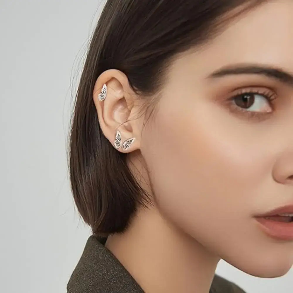 close-up side view photo of a woman wearing silver butterfly earrings