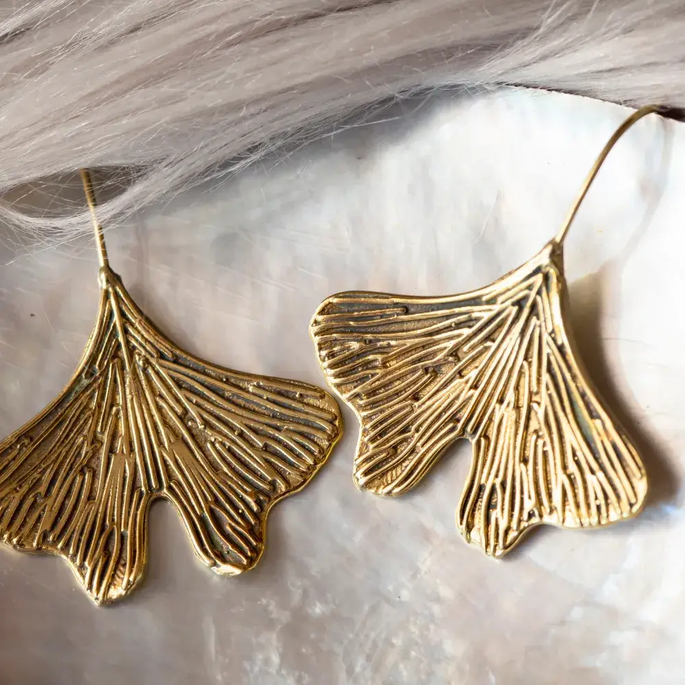 brass metal earrings in the shape of gingko biloba leaf