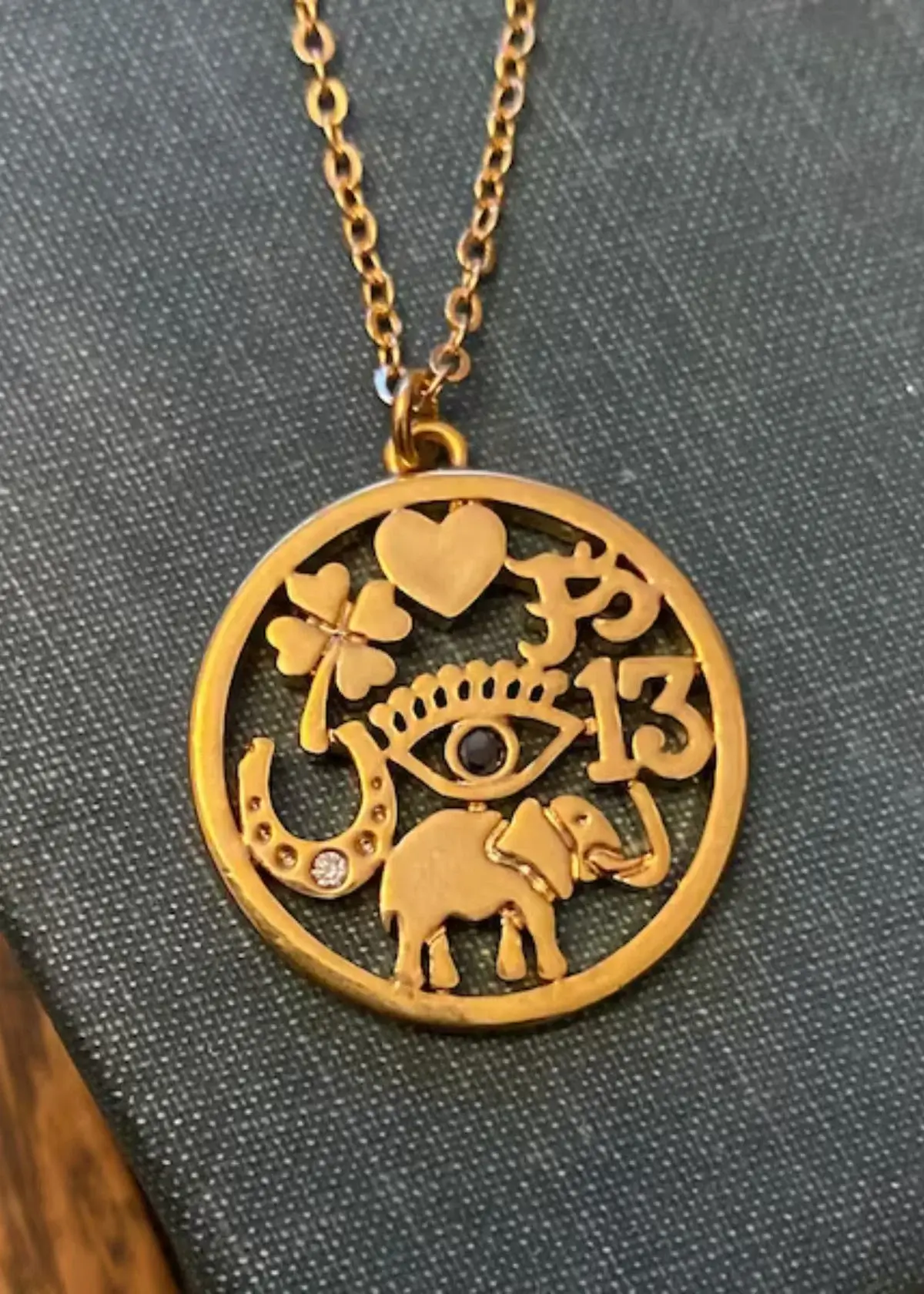 What are some common symbols used in lucky charm necklaces?
